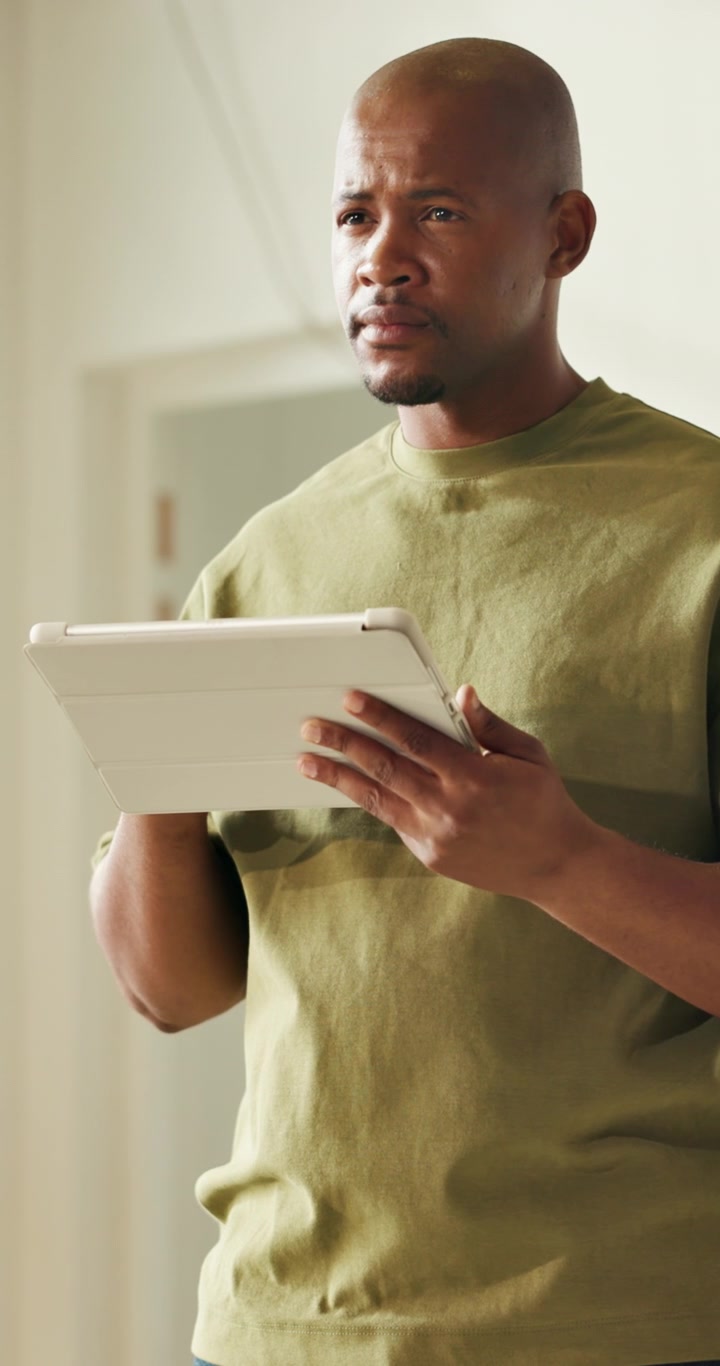 Focused Man Using a Digital Tablet in a Bright Room