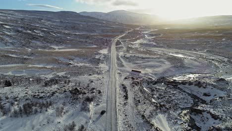 Fahren-Auf-Einer-Straße,-Die-Durch-Die-Verschneite-Landschaft-Zu-Den-Bergen-Der-Phantominsel-In-Island-Führt---Aus-Der-Luft