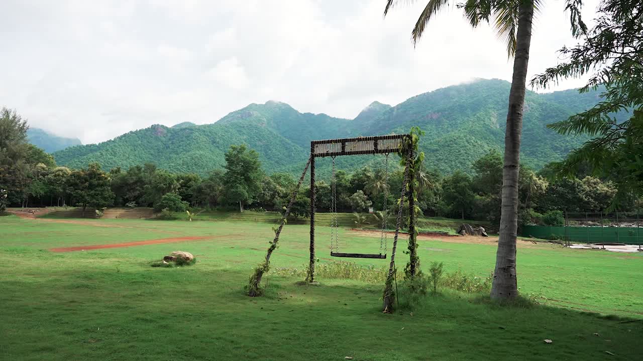 푸른 풀, 나무, 먼 산에 둘러싸인 울창한 공원에서 펼쳐진 아름다운 스의 넓은, 구름이 가득한 하늘 아래, 자연과 평화로운 연결을 불러일으킨다.