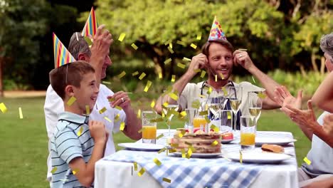 animation of confetti falling over happy family at birthday party