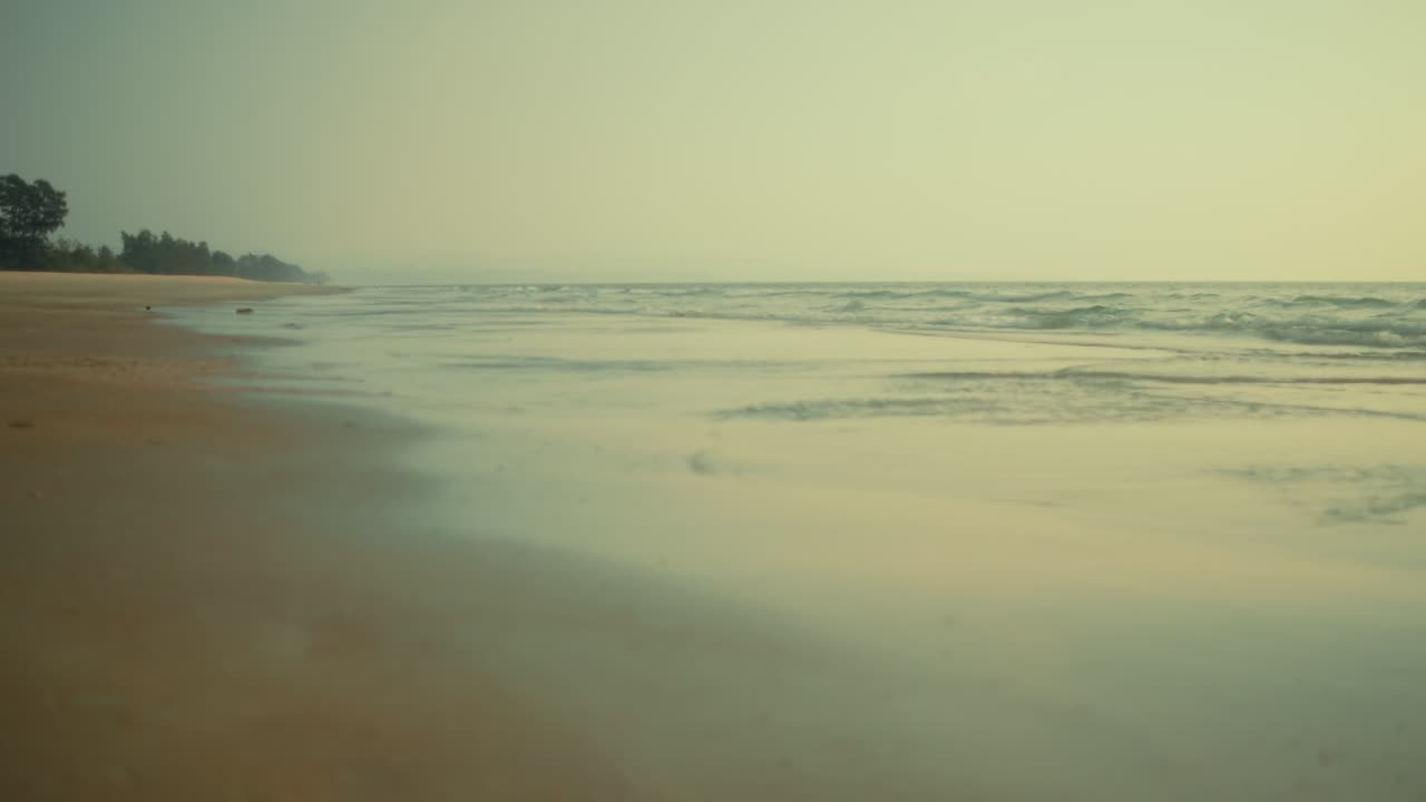 Gentle waves flow over a sandy tropical beach in soft pastel colors. This dreamy and serene landscape captures the concept of tranquility and summer peace
