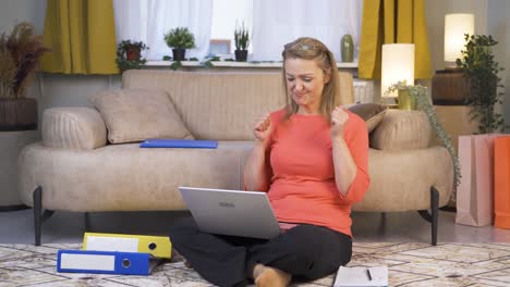 woman looking at laptop making positive gesture.
