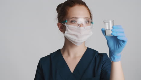 redheaded doctor in front of camera on gray background.