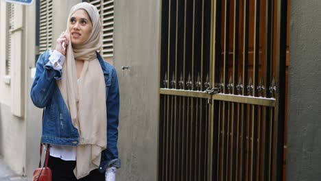 Woman-in-hijab-talking-on-mobile-phone-while-walking-on-the-street-4k