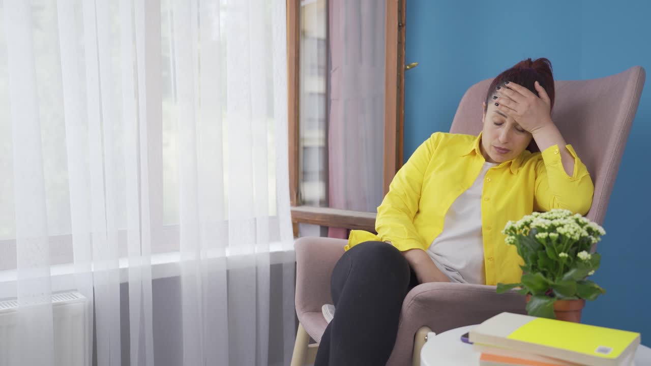 아픈 여자는 긴장을 풀기 위해 창문 밖을 바라본다.