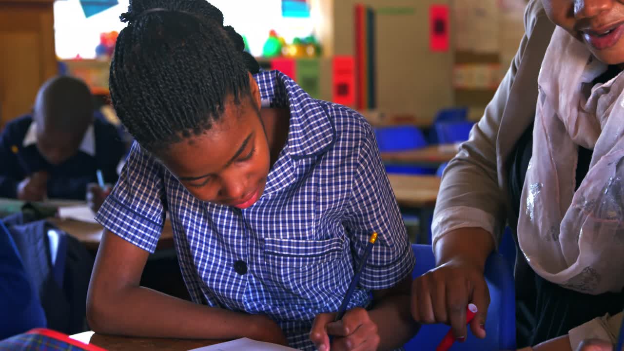 Teacher helping schoolchildren in a lesson at a township school 4k