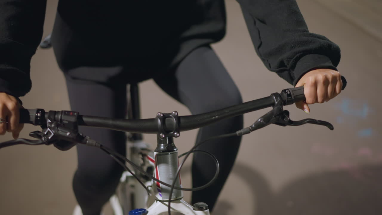 Controlling Steering Through Late Evening Lighting, Hands Firmly Grasped On Handlebars During Evening Park Ride, Maintaining Stable Control And Steering Through Softly Illuminated Pathway At Night