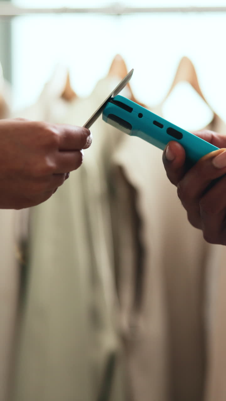 Hands Tagging Clothing and Preparing a Shopping Bag in a Retail Store