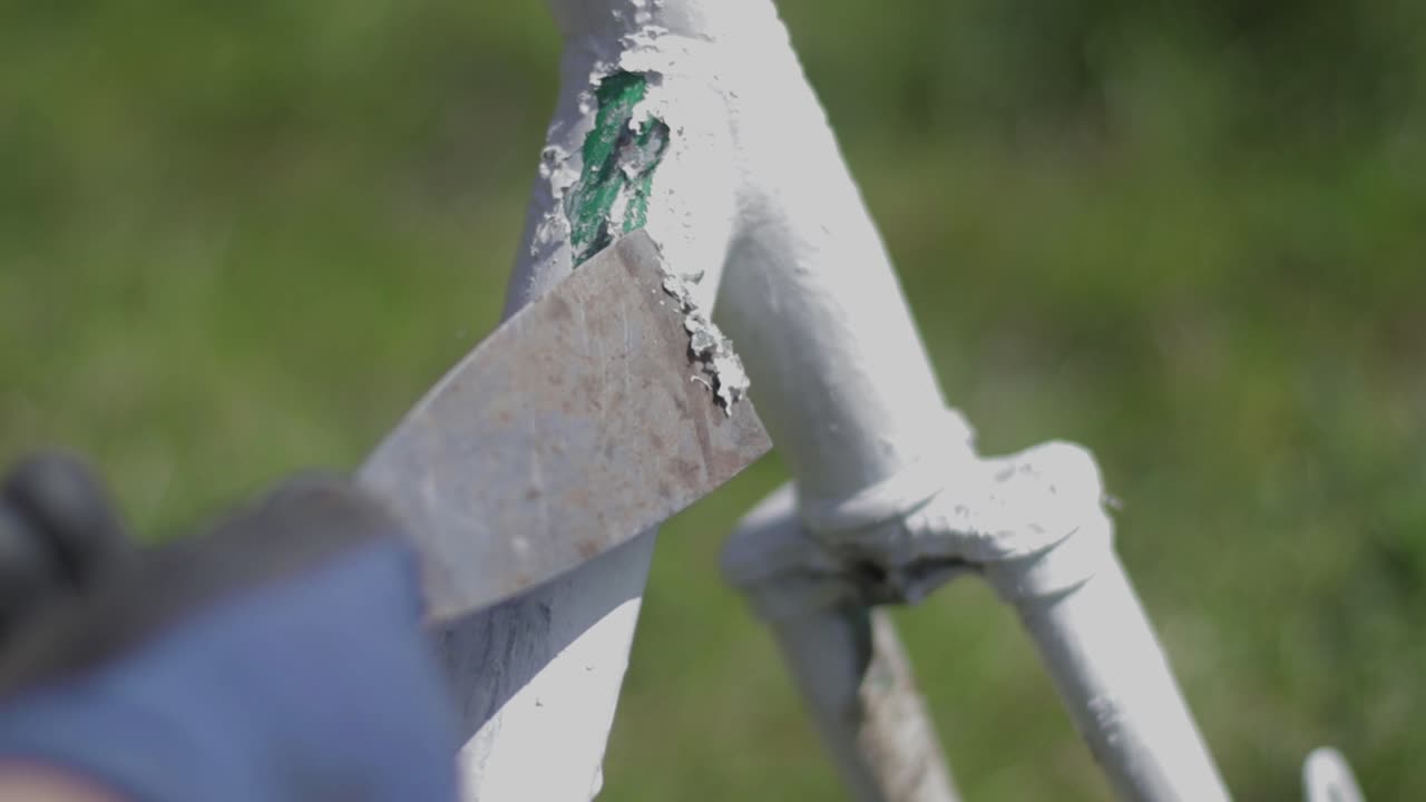 Mechanic scrubs the paint on an old bicycle. Bike restoration. Bicycle repair.