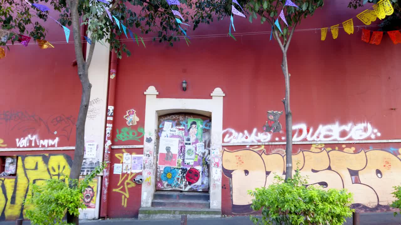 Visuale panoramica sinistra di un muro urbano colorato, ricoperto di poster di graffiti e texture di street art