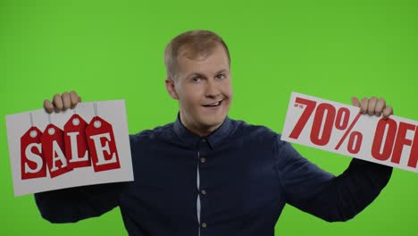 cheerful man showing sale word and showing up to 70 percent off inscription. black friday concept