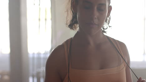 wearing sportswear, woman standing in gym, looking confident and focused