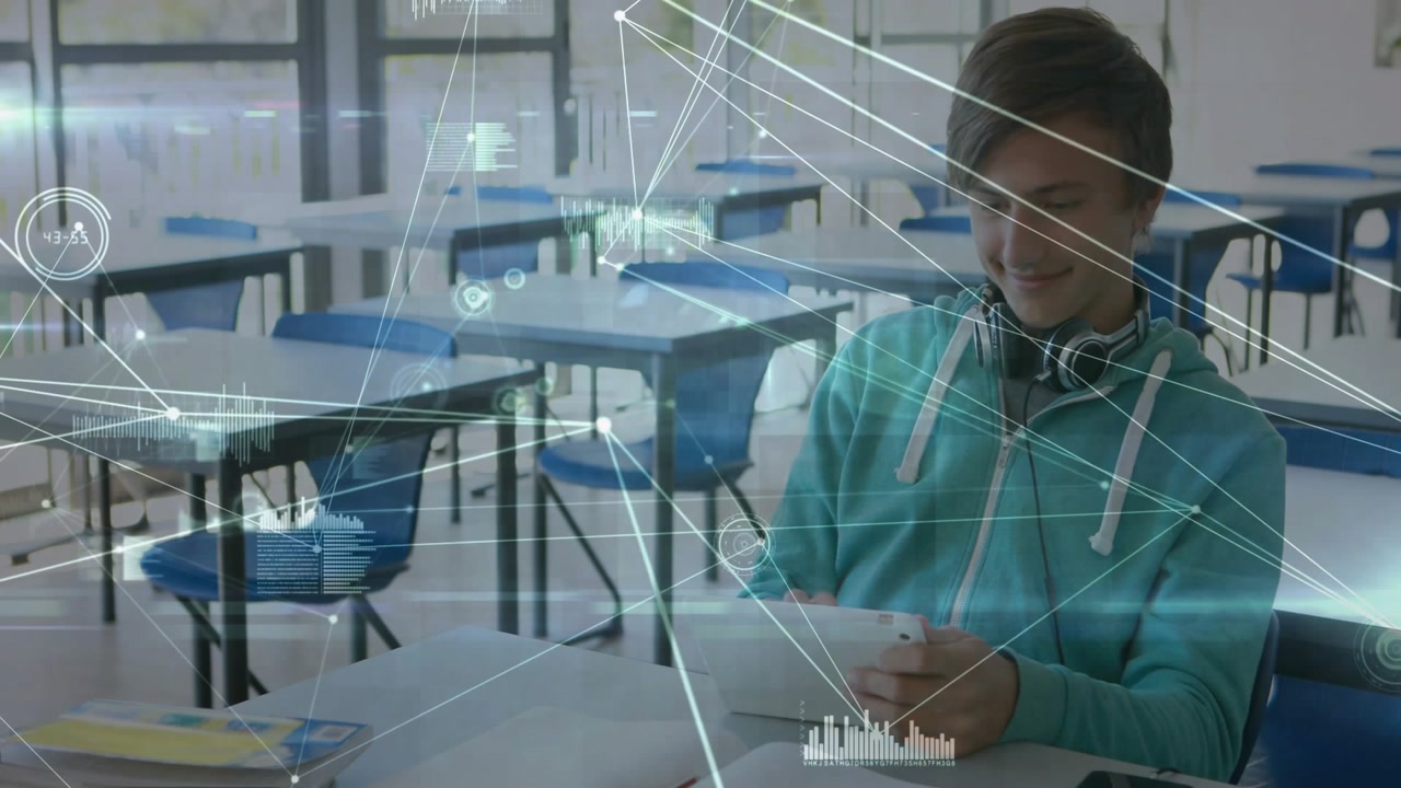 Teen male student tapping tablet in classroom, causing data overlay moving showing graphs for study