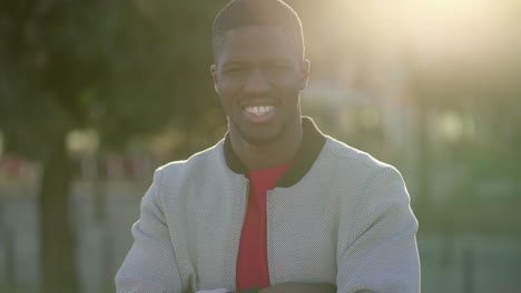 hombre de pie con las manos cruzadas, con confianza, sonriendo