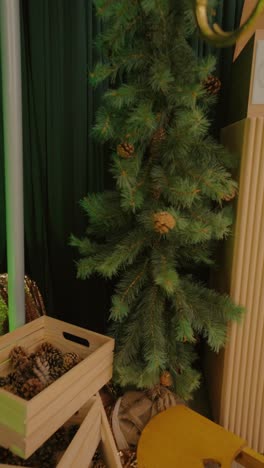 un rincón cálido y festivo decorado con cajas de madera, piñas y acentos de hoja perenne, creando una acogedora y nostálgica atmósfera navideña en el interior.