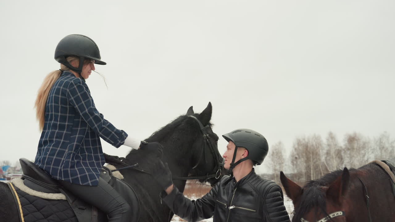 Celebrazione tra cavalli. Addestratore e cavaliere gioiscono all'aperto. Un paesaggio innevato ospita un momento gioioso con cavalli e addestratore. Addestratore e cavaliere condividono un orgoglioso risultato in mezzo a un paesaggio innevato scenografico.