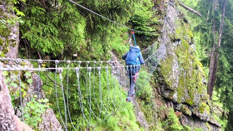 hikers on precarious bridge, ferrata hans kammerlander trail in the alta badia dolomites, italy, slow-motion showcasing rocky landscapes and alpine beauty