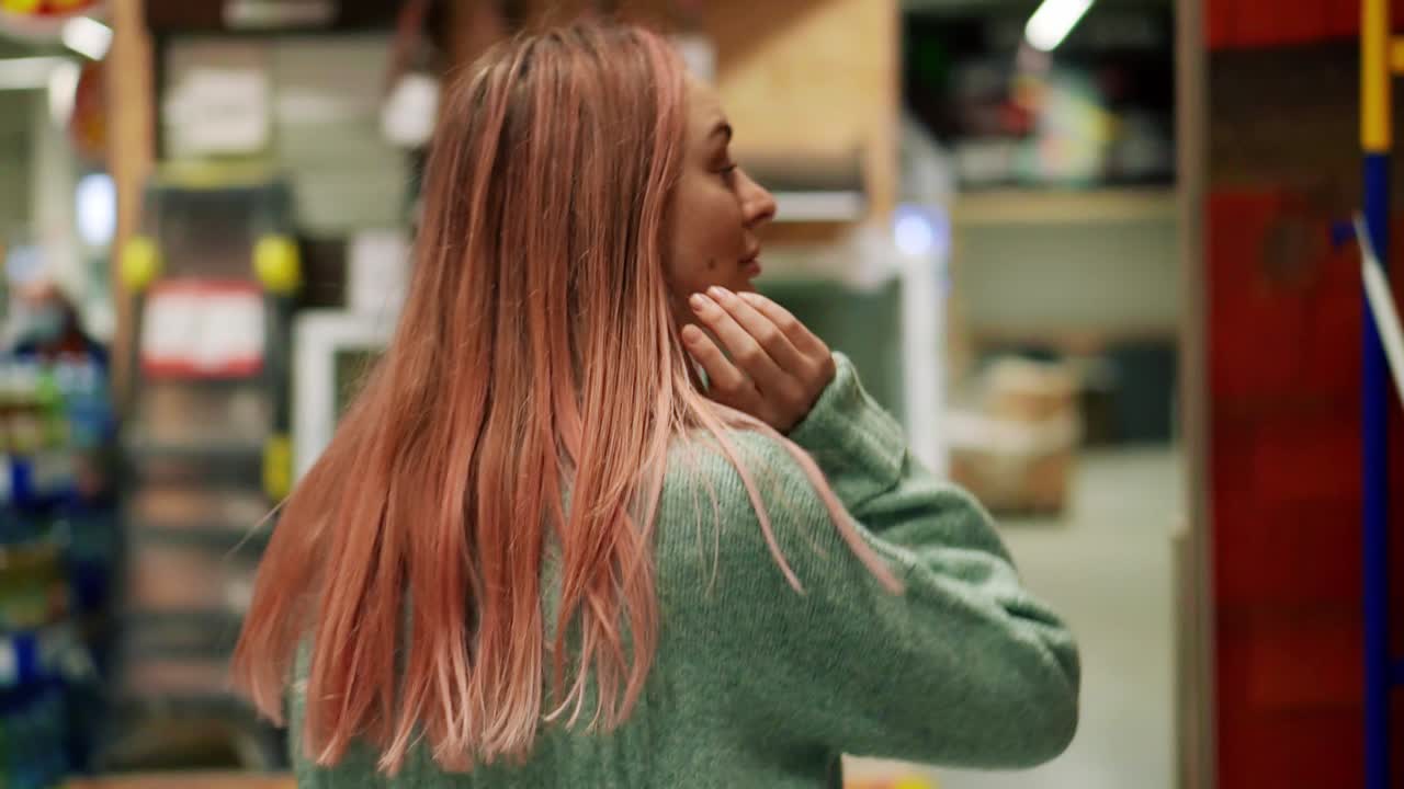 카메라를 보고 철물점을 걷고 있는 여성의 초상화