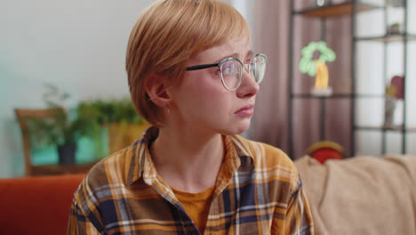 Upset disappointed young woman wipes tears and cries from despair unrequited love problems at home