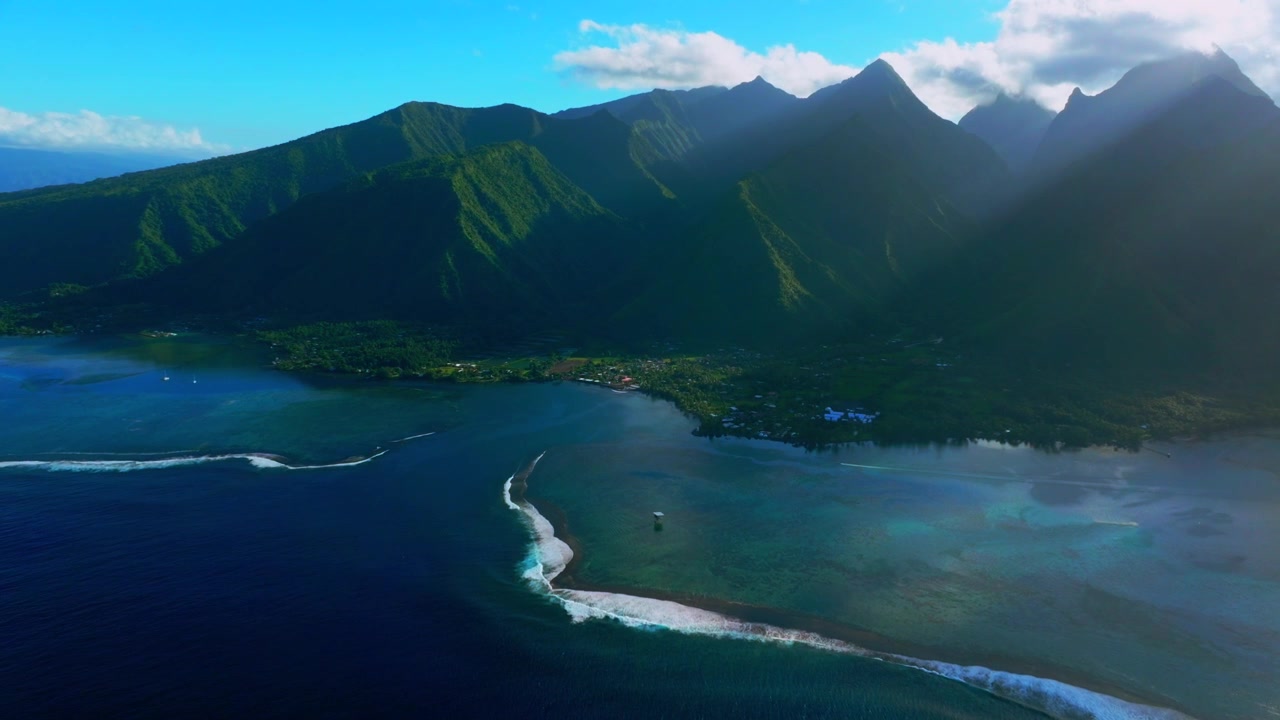 Surf Town of Teahupo'o Tahiti lagoon aerial drone harbor view French Polynesia Passe Havea coral reef wave South Pacific Ocean island landscape sunny sun rays volcano peaks coastline backwards