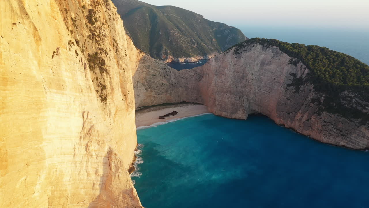 impresionantes imágenes de drones de la playa de naufragios de zakynthos, destacando los dramáticos acantilados y las aguas azules de la playa navagio
