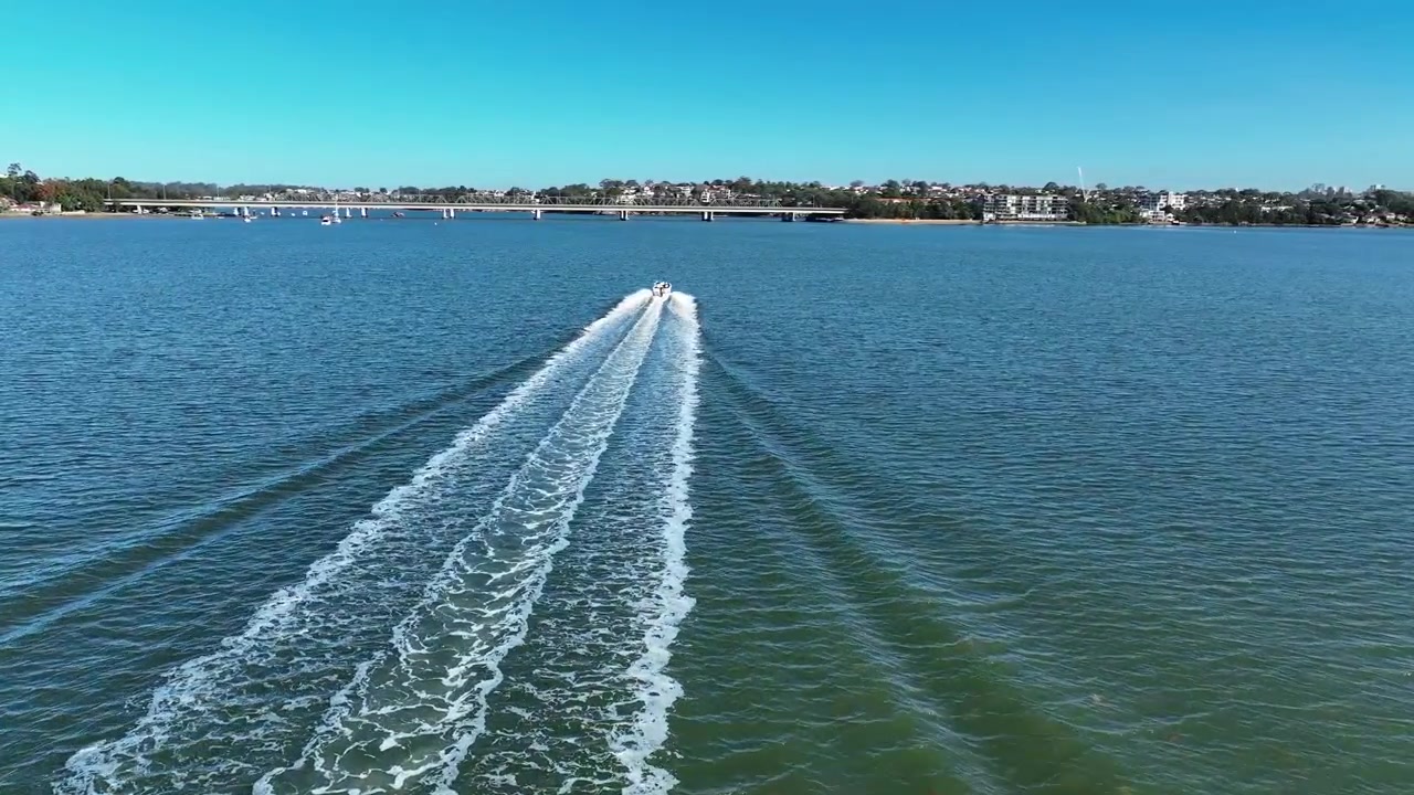 Drone che segue una barca che risale il fiume Georges, Sydney, Australia.