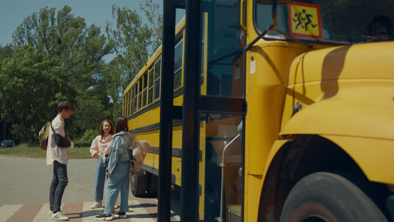 dos compañeros de clase dejan la puerta abierta del autobús escolar. los alumnos salen de la lanzadera académica.