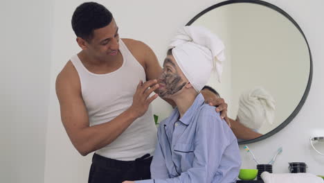hombre negro guapo aplicando exfoliante a una mujer