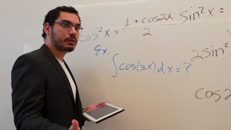 teacher demonstrating a problem on a whiteboard