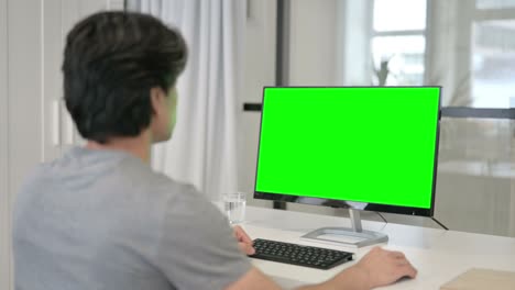 녹색 크로마 키 스크린을 가진 데스크을 사용하는 사업가