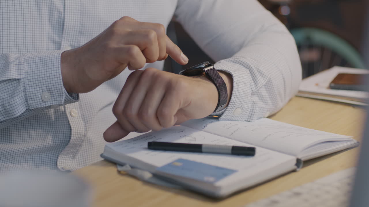 Businessman Checking Time on Smartwatch at Desk