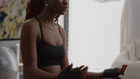 athlete woman with dark skin wearing sportswear practicing yoga at home