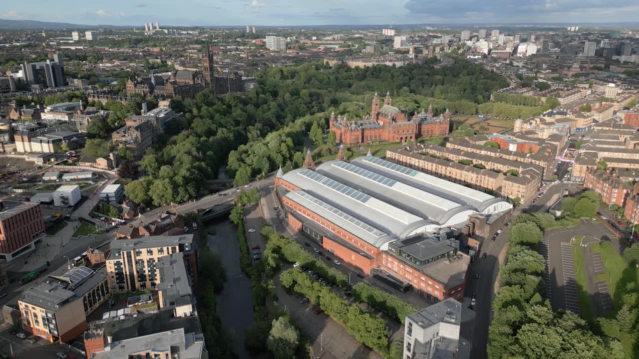 Aerial orbit around Kelvin Hall museum and its solar panels on roof with Glasgow University in background, Glasgow, Scotland, UK