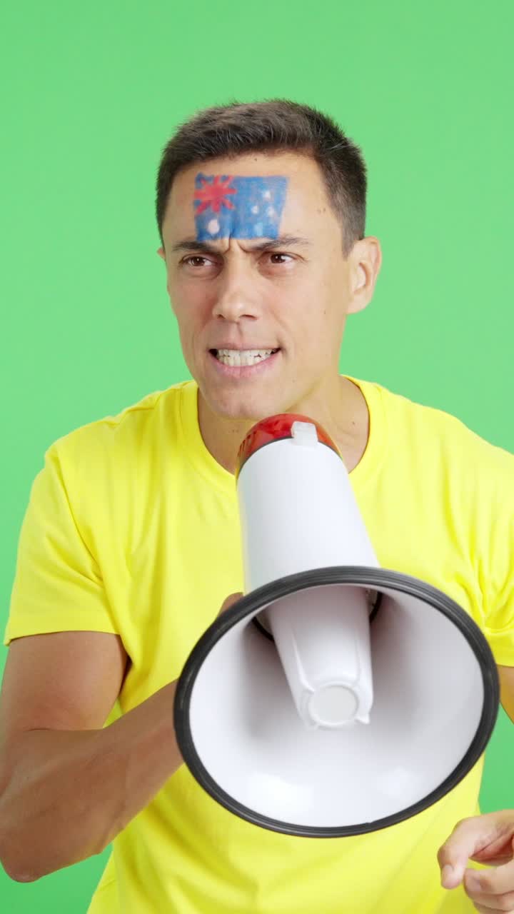 Excited man with australian flag on face using a megaphone