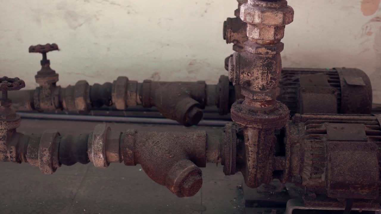 viejo y oxidado motor de bomba de agua y tuberías. tiro de inclinación de derecha a izquierda.