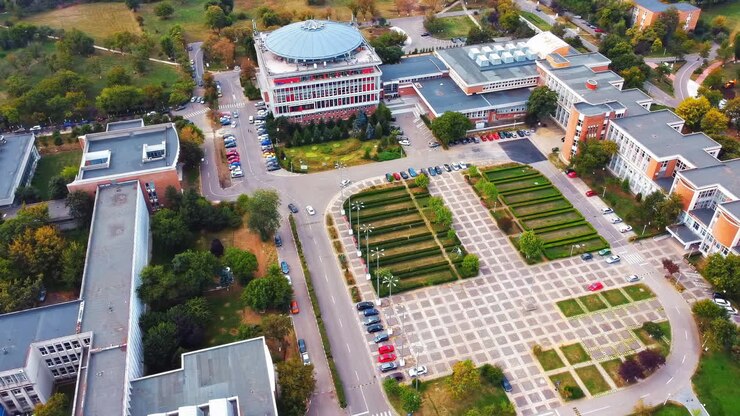 Vista aérea de drone do campus universitário entre o verde e as casas residenciais. Bucareste, Romênia