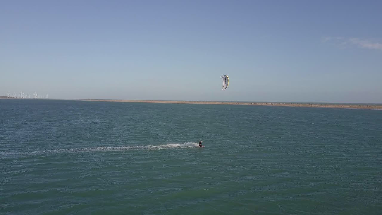 imágenes de drones de un kiteboarder surfeando en la costa de combuco, brasil