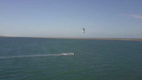 drone footage of a kiteboarder surfing on the coast of combuco, brasil