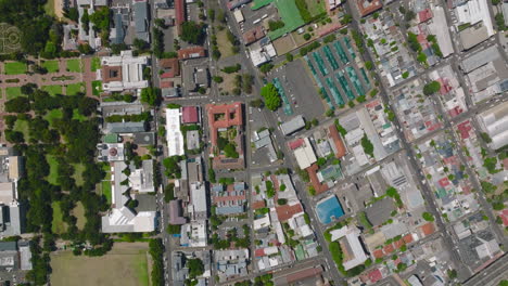 Top-down-panning-shot-of-urban-neighbourhood-on-sunny-day.-Streets-and-houses-in-city-from-height.-Cape-Town,-South-Africa