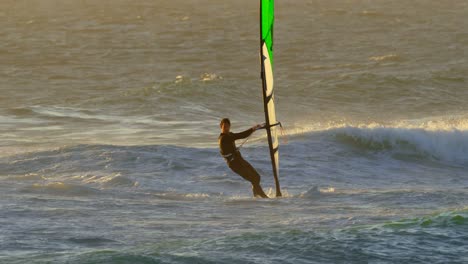 surfista masculino haciendo windsurf en la playa 4k