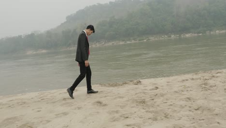 businessman walking along a riverbank