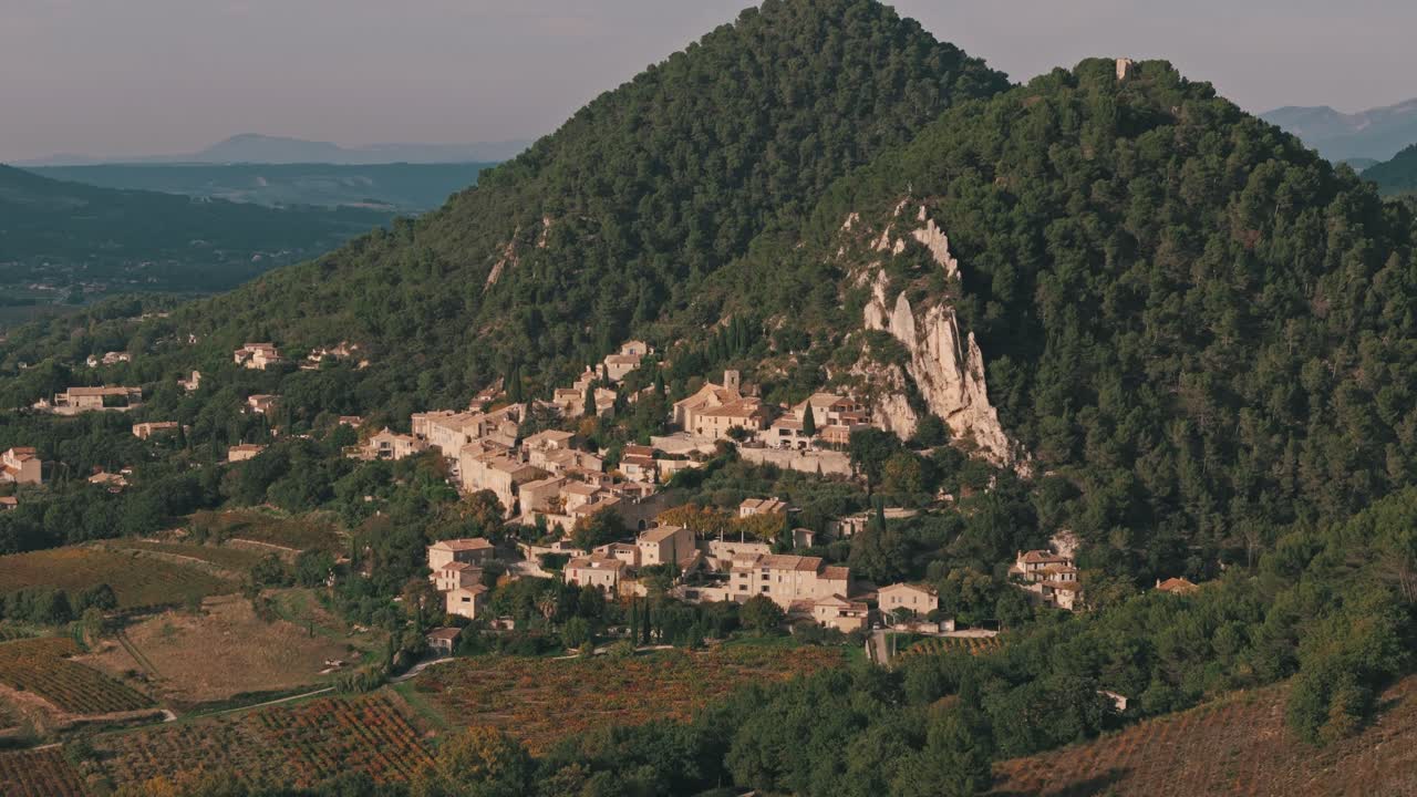 Aerial flyover ascend to establish Seguret village in Provence, France, showcasing the scenic architecture and rolling hills landscape
