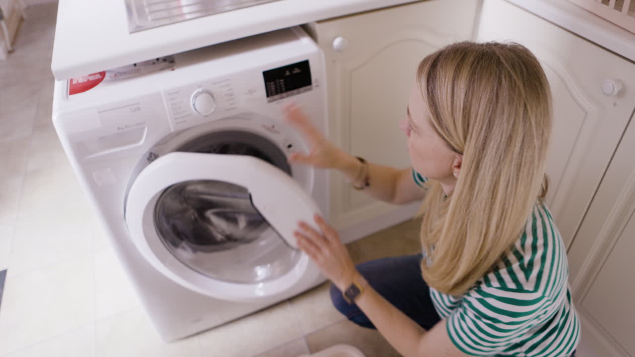 mujer lavando la ropa en casa