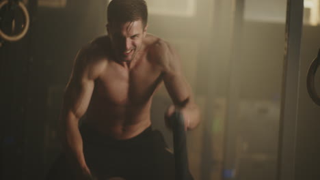 man performing a rope workout in a gym