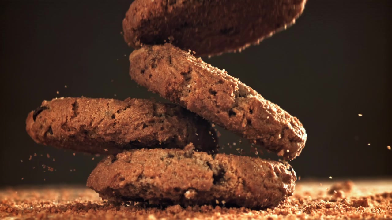 Biscoitos com gotas de chocolate caindo e se empilhando em câmera lenta