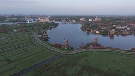 Seitenschwenkaufnahme-Der-Landschaft-Der-Windmühlen-Von-Zaanse-Schans-Bei-Sonnenaufgang,-Luftaufnahme