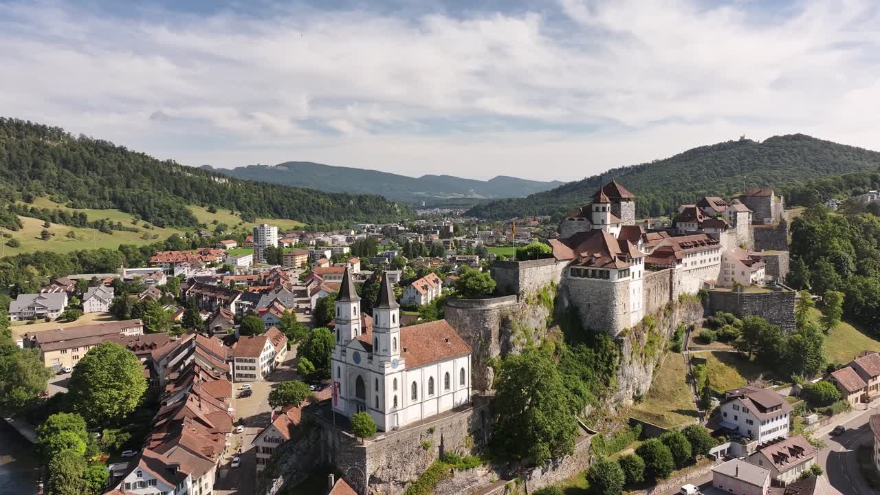 Aerial view of Aarburg with historic castle, church, and Aare River surrounded by lush hills in Switzerland