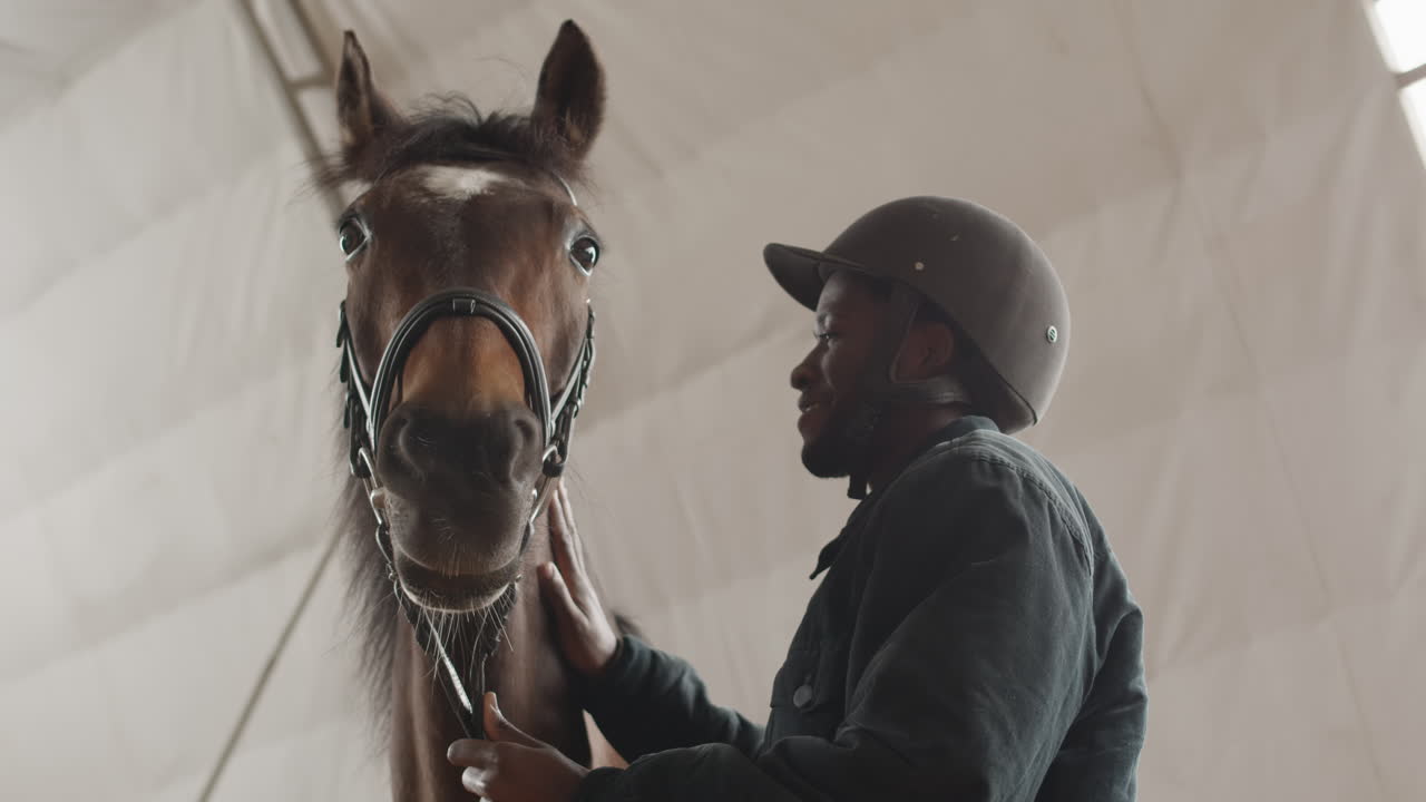 hombre acariciando un caballo en un establo 1