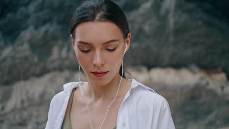 calm woman wearing headphones in front sandy hill closeup. woman listening music