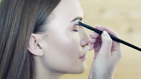 make up stylist makes smokey eyes effect for model at photo shoot